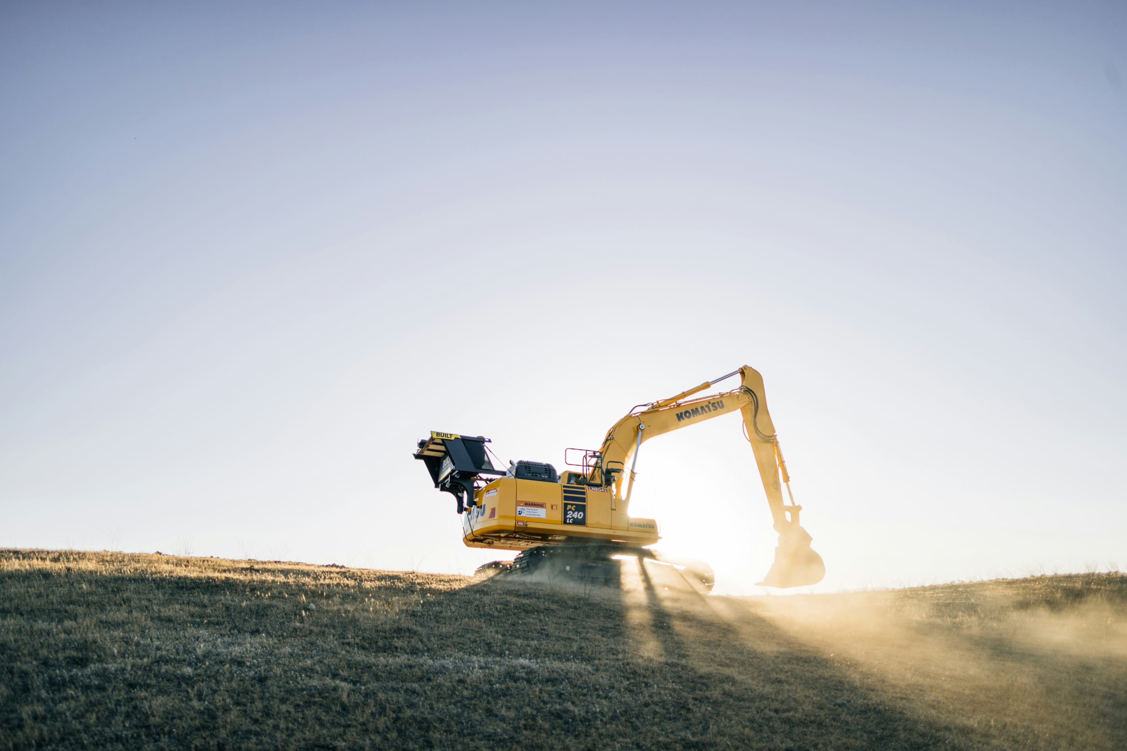 Komatsu Bagger auf einer Baustelle bei Sonnenuntergang